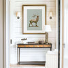 elk drawing in a gilded frame over a console table in an entryway with shiplap walls