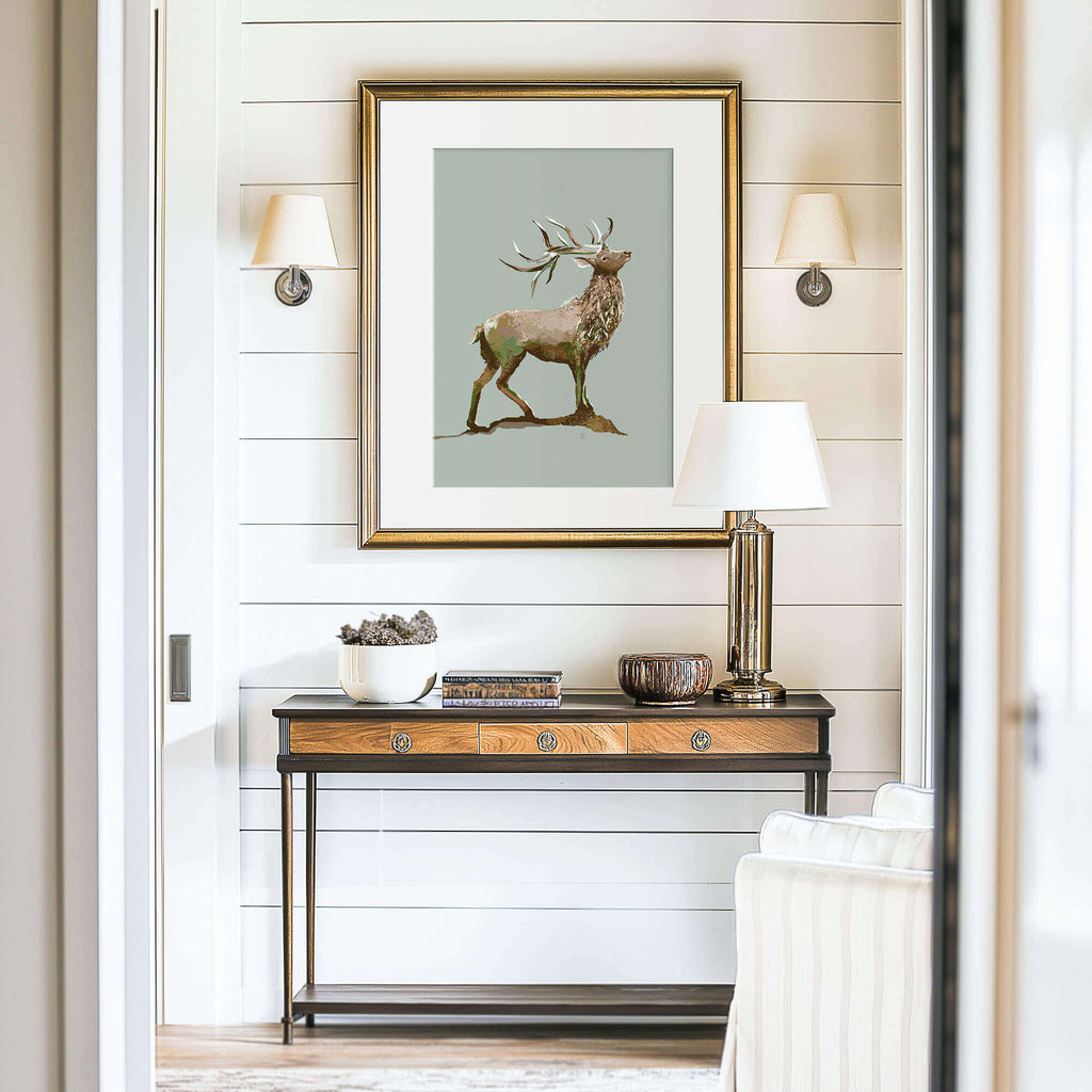 elk drawing in a gilded frame over a console table in an entryway with shiplap walls