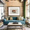 framed fox drawing over a sofa in a mountain house living room. the walls are solid wood beams and the sofa is greenish blue.