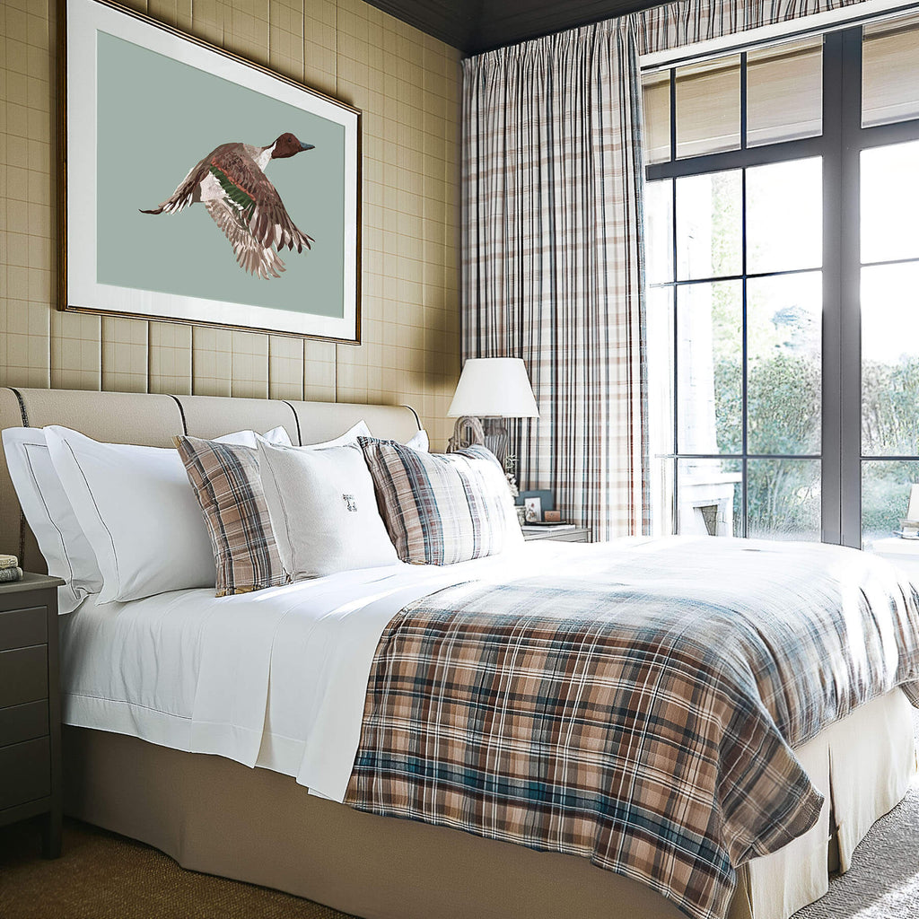 pintail duck painting in a bedroom with plaid bedding
