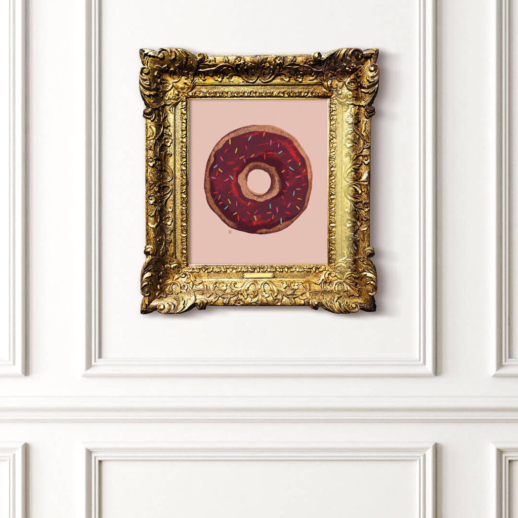 chocolate doughnut art print in gold frame.